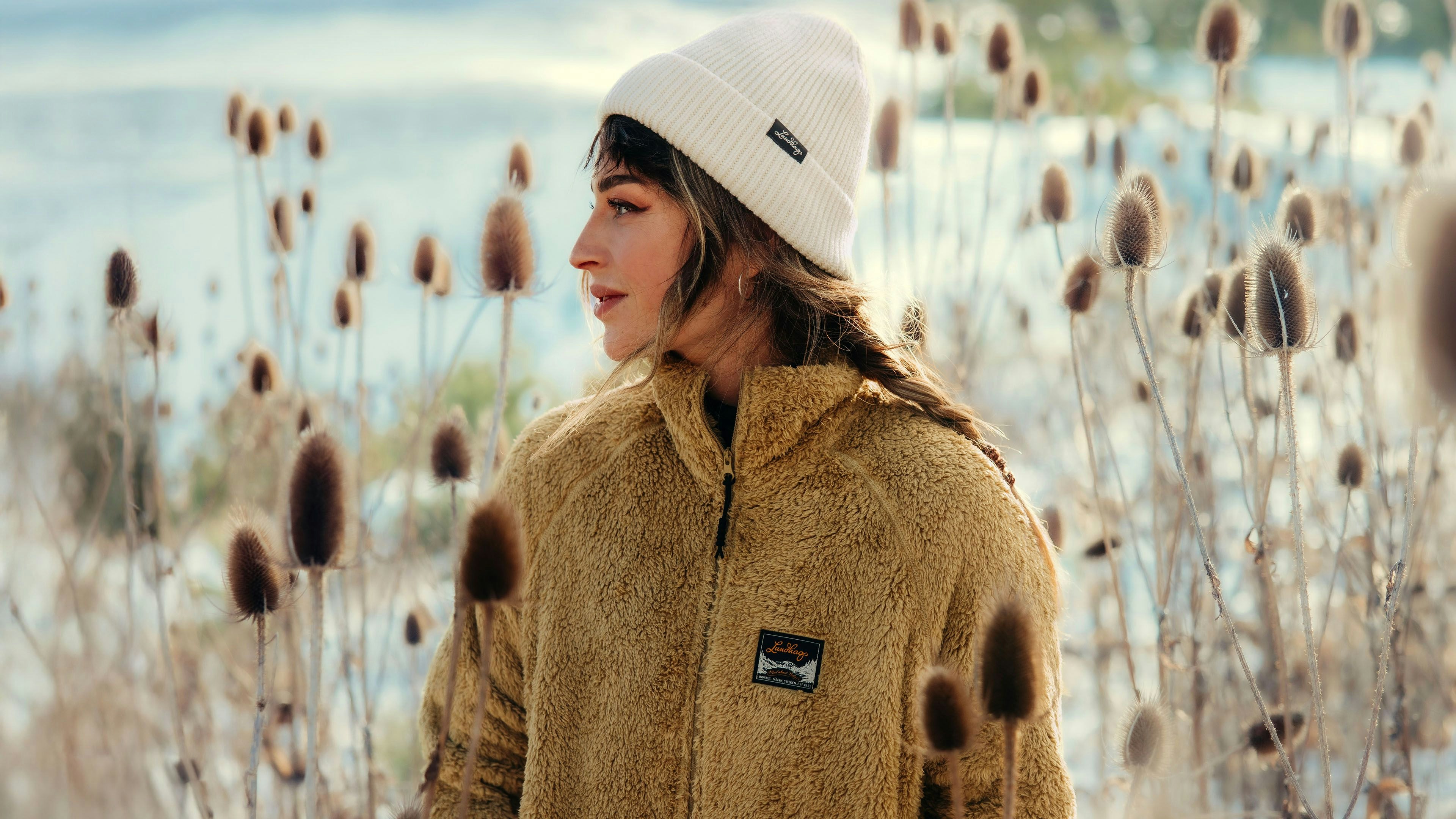 Women sitting besides a lake in a fleece midlayer