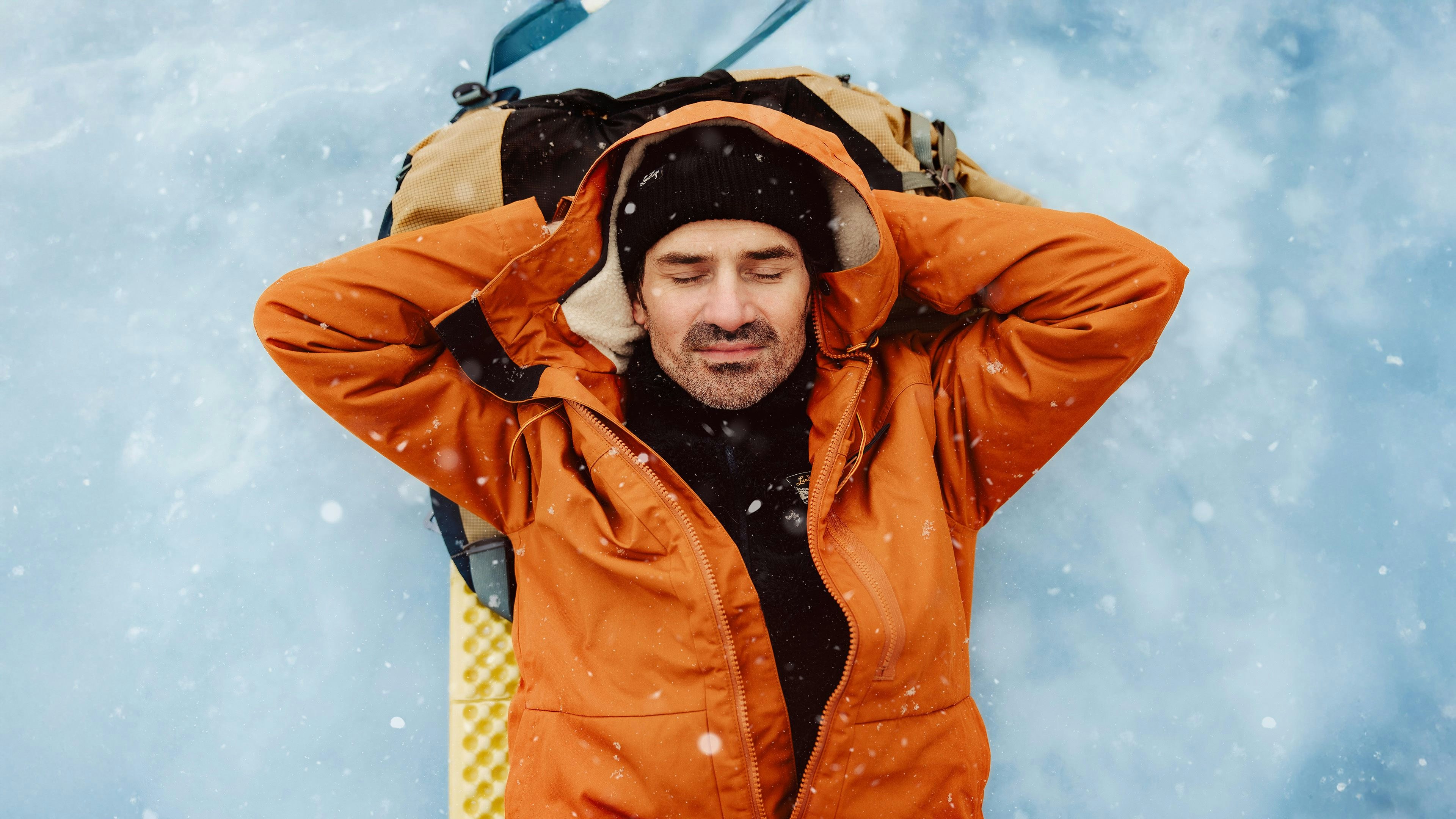 Men laying resting on a frozen lake